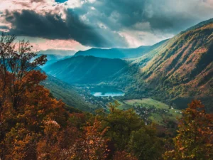 Panoramic view of Boračko Lake surrounded by green mountains under a dramatic cloudy sky