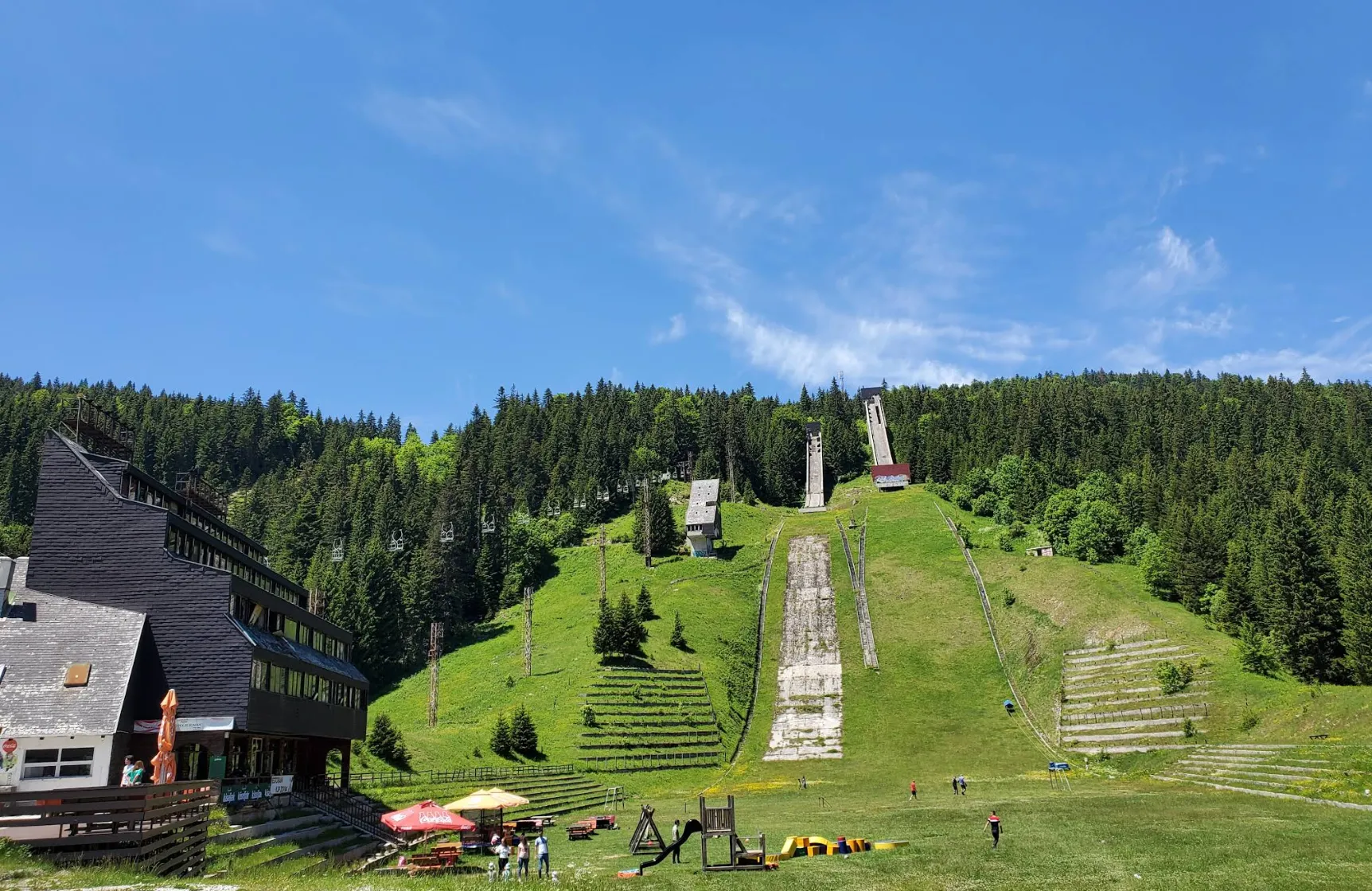 Olimpijske skakaonice na Planini Igman u ljeto, zelene padine i šuma u pozadini