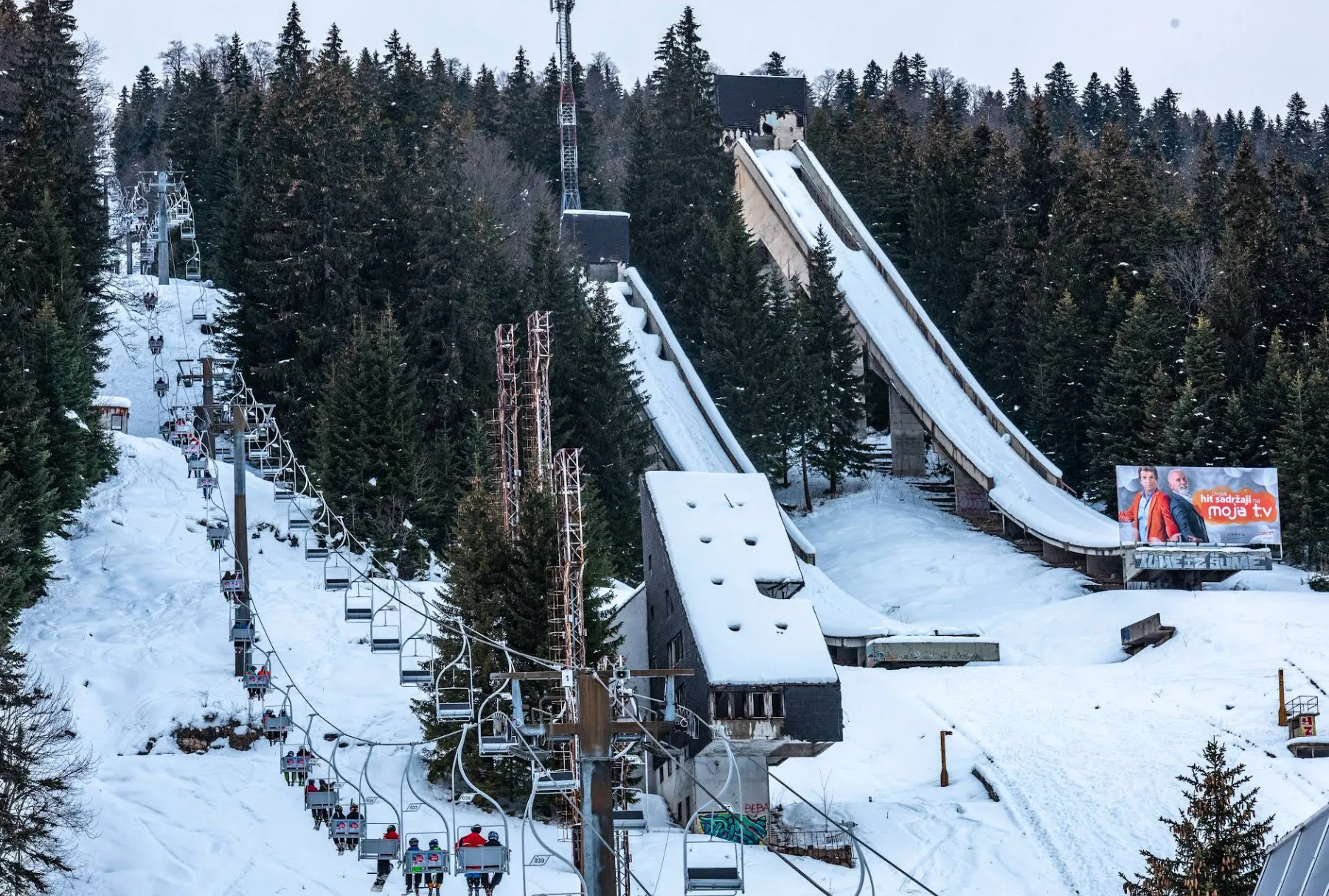 Olimpijske skakaonice na Planini Igman prekrivene snijegom, zimski pejzaž sa četinarskom šumom