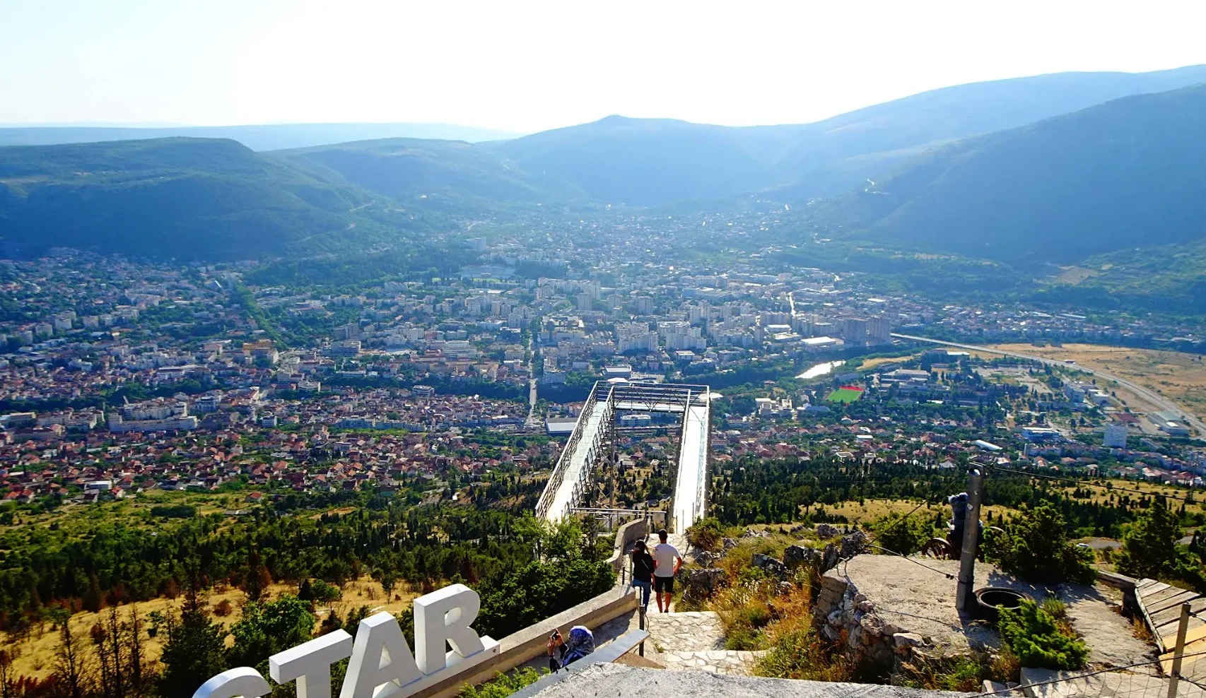  Panoramski pogled na Mostar sa vidikovca Fortica, planine oko grada i staza koja vodi prema platformi