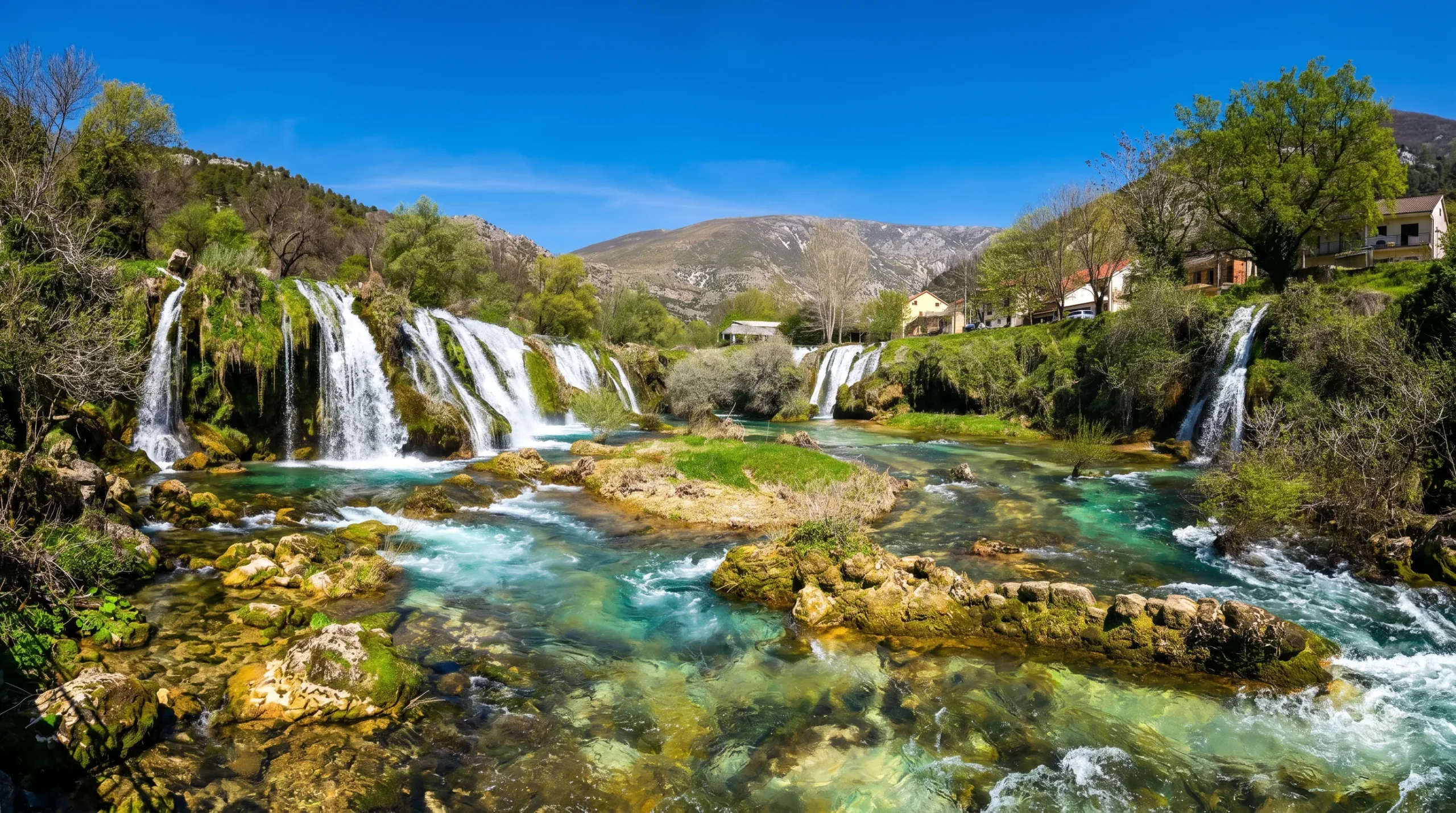 Wide view of the clear water and natural surroundings of Provalije Waterfall