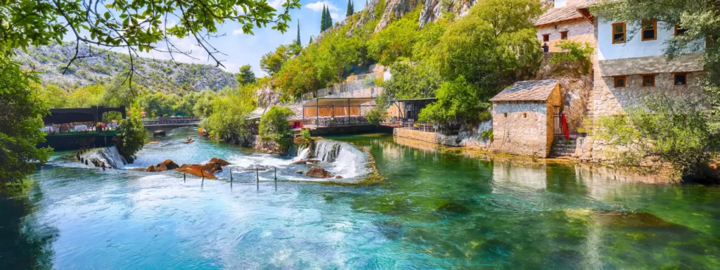 Blagaj Mostar Panoramski pogled na selo Blagaj uz rijeku Bunu, stare kamene kuće i mlinovi uz tirkiznu vodu okruženu bujnim zelenilom