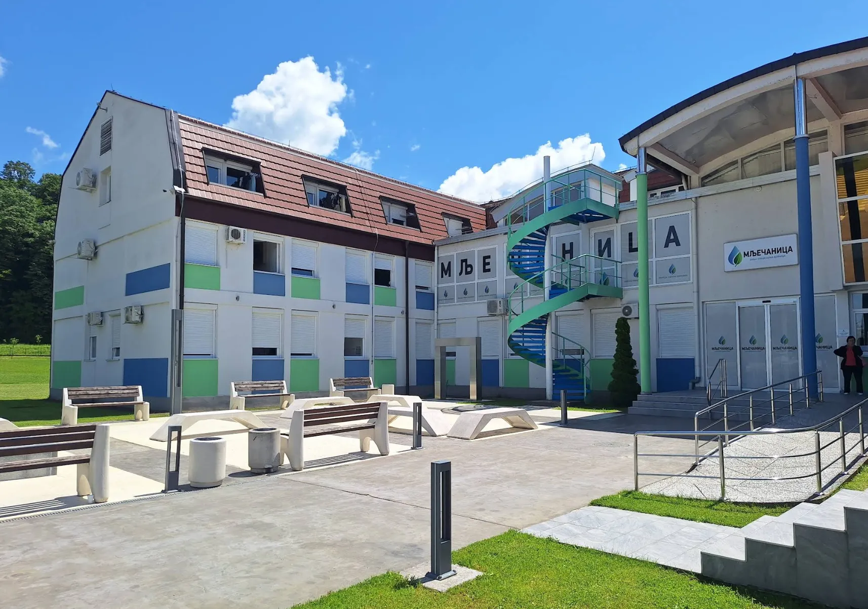 Eksterijer Banje Mlječanica sa uređenim parkom i zelenim površinama pod vedrim nebom