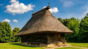 Tradicionalna pravoslavna crkva brvnara od tamnih drvenih talpi sa karakterističnim, izuzetno visokim i strmim krovom pokrivenim drvenom šindrom, pod plavim nebom