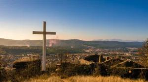 Bijeli križ na uzvišenju iznad Širokog Brijega, pored ostataka kule u zalazak sunca