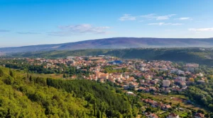 Široki pogled na urbanu panoramu grada Širokog Brijega okruženog zelenim brežuljcima