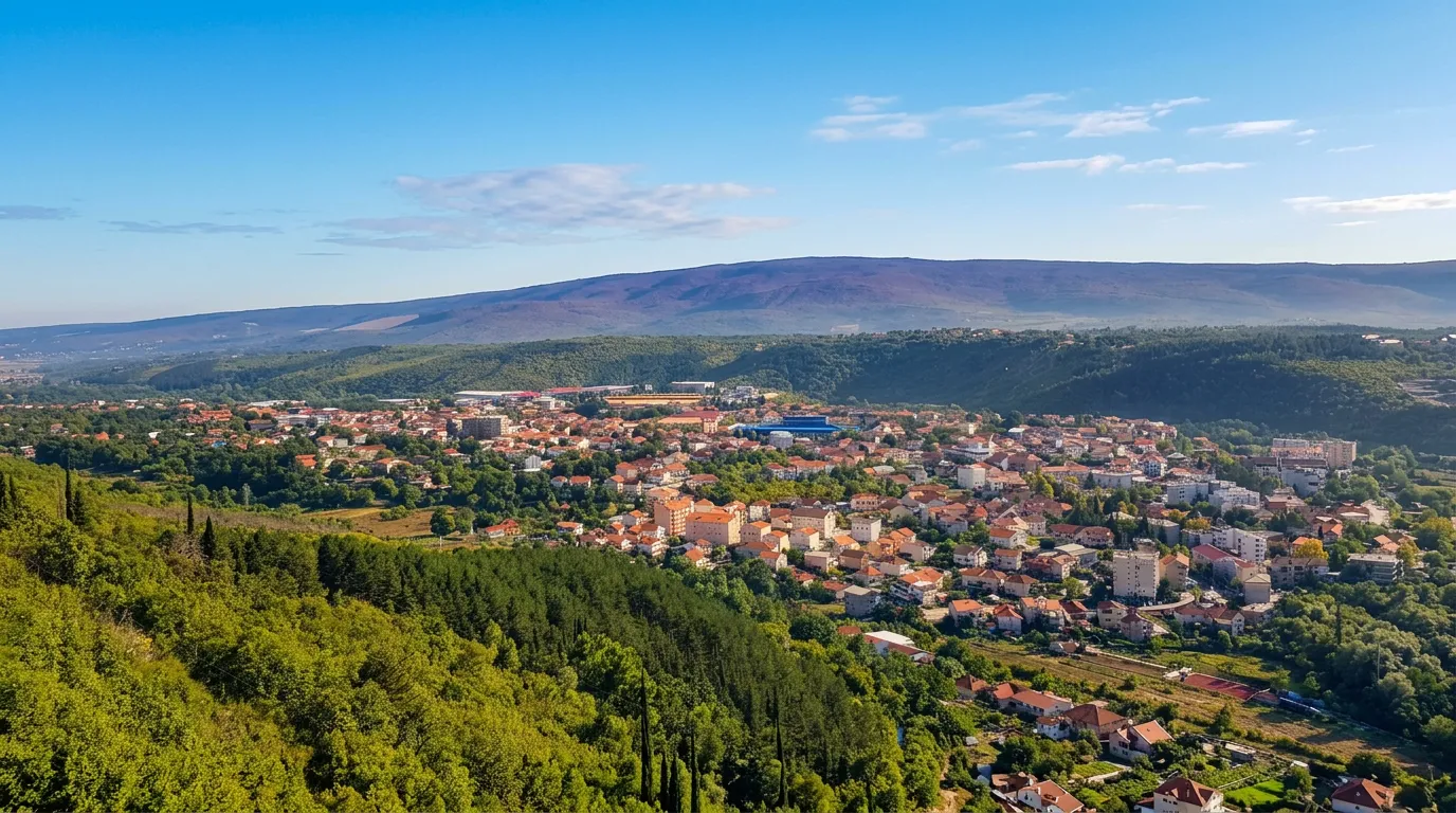 Široki pogled na urbanu panoramu grada Širokog Brijega okruženog zelenim brežuljcima
