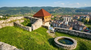 Doboj kalesinin üst kısmından ahşap kule yapısına, taş surlara ve dağlarla çevrili vadide yer alan Doboj şehrinin panoramasına bakış