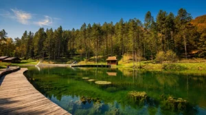 Calm water and a promenade beside Goransko Lake with a wooden cottage