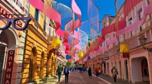 Numerous pedestrians in Gospodska ulica beneath a lavish and dynamic street decoration with bright pink and pastel ribbons creating a striking visual effect