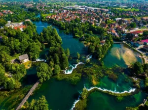 Pogled odozgo na Bihać i rijeku Unu sa slapovima, zeleno gradsko područje uz obalu