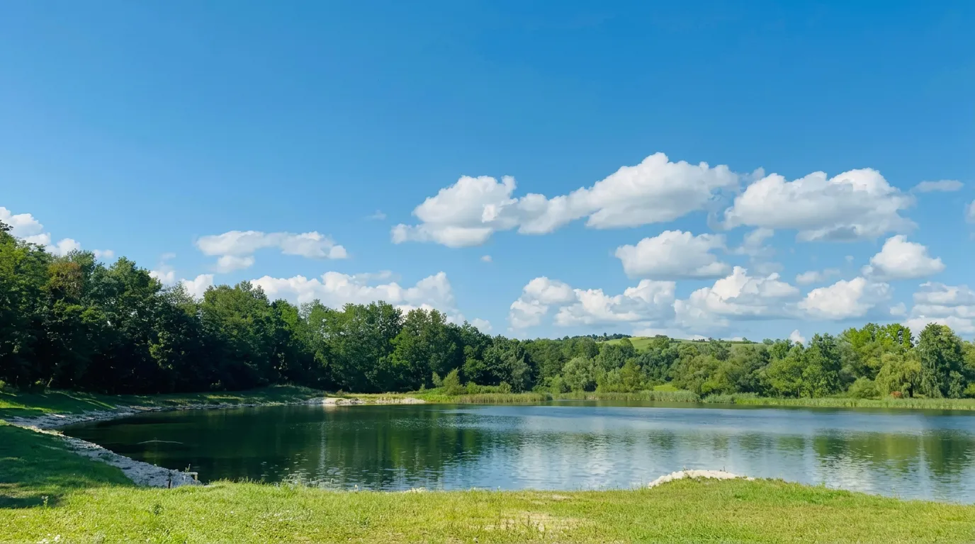 Wooded shore and the calm waters of Bistarac Lake on a sunny day