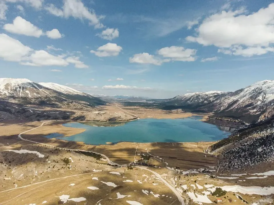 Ptičja perspektiva Jezera Blidinje na visoravni između planina Čvrsnice i Vrana, snijeg na vrhovima