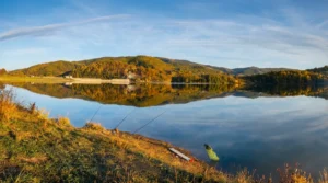 Štapovi za pecanje na mirnoj obali jezera Drenova tokom sunčanog dana