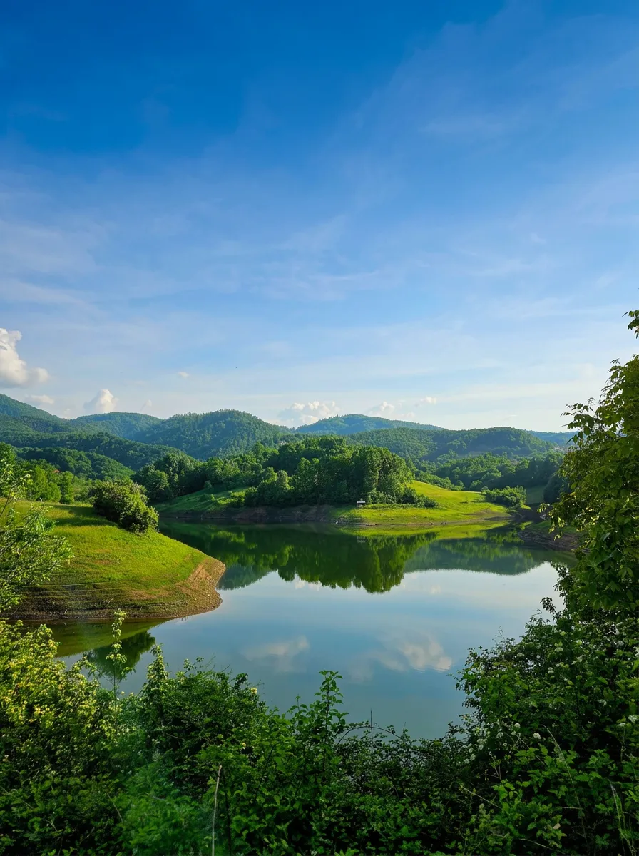 The calm surface of Hadžije Lake surrounded by green hills