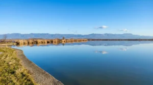 Clear water of Ribnjak Saničani Lake with a mountain horizon in the background