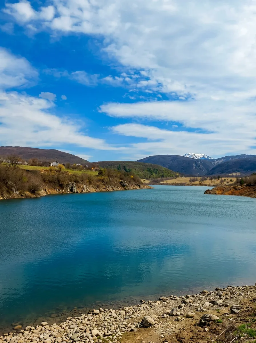 Clear water of Župica Lake with a mountain massif in the background