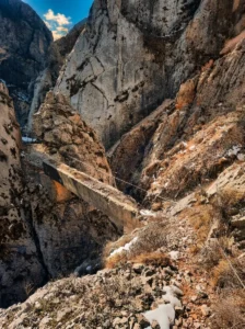Ričina Nehri kanyonunun kayalık ve karstik manzarası içinde eski beton geçidin ya da yapının görünümü