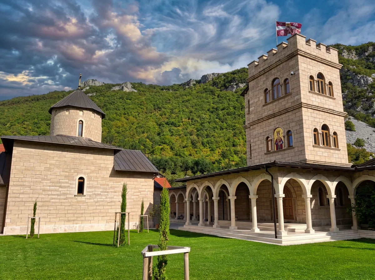 A close-up of the monastery church and residence with open semicircular arches (a porch) and a massive stone tower, under a dynamic blue sky with white clouds