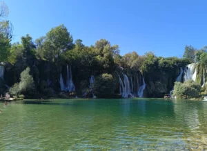 Panoramski pogled na slapove i tirkizno jezero rijeke Une u Martin Brodu okruženo zelenilom