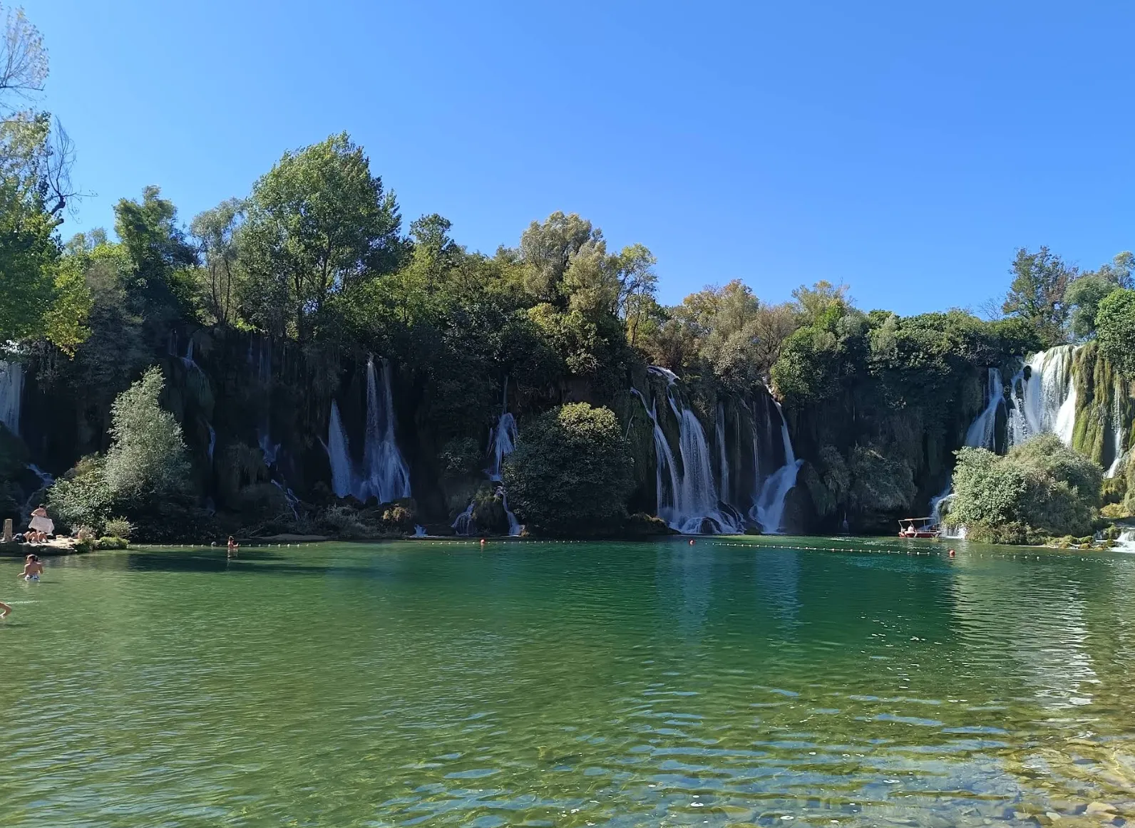 Panoramski pogled na slapove i tirkizno jezero rijeke Une u Martin Brodu okruženo zelenilom