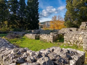 Ruins of a late antique Roman villa rustica up close, with grassy interior areas and distinctive stone structures under a sunny sky