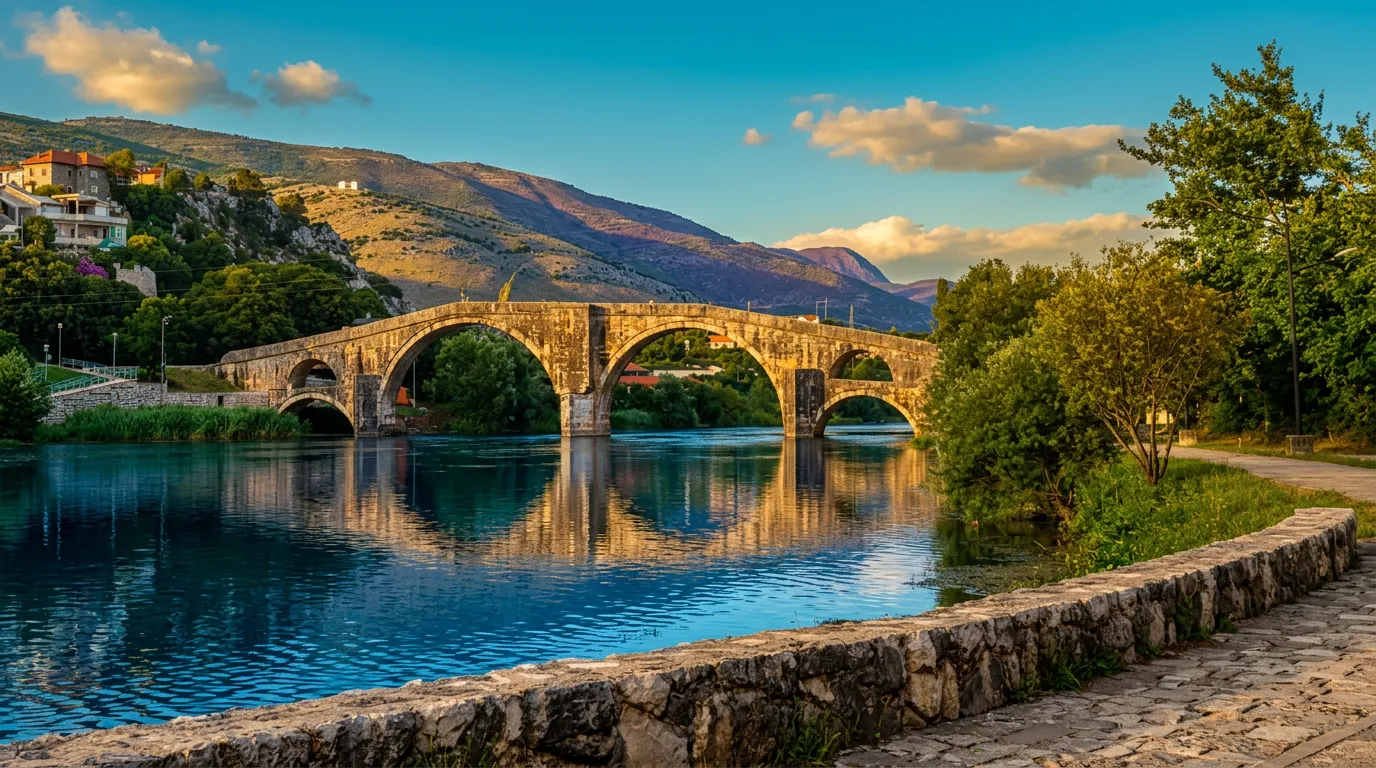Pogled na kamniti Arslanagića most, ki se zrcali v mirni vodi reke Trebišnjice