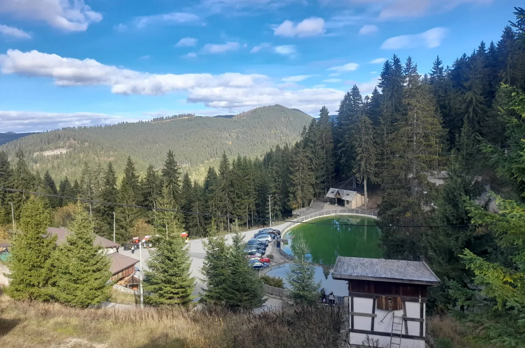Ljetni pejzaž Planine Vlašić sa planinarskim domom i bazenom, zelene šume i planine u pozadini