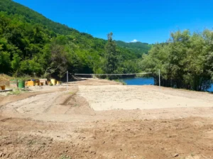 A sandy volleyball court at Desetka beach by the river