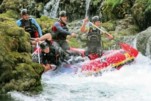 Uzbudljiv rafting tim u čamcu na brzacima rijeke Une