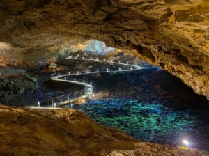 Illuminated walking path through the interior of Ravlića Cave