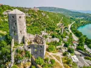 Ptičja perspektiva Starog grada Počitelja, kamene kule i bedemi okruženi gustim zelenilom