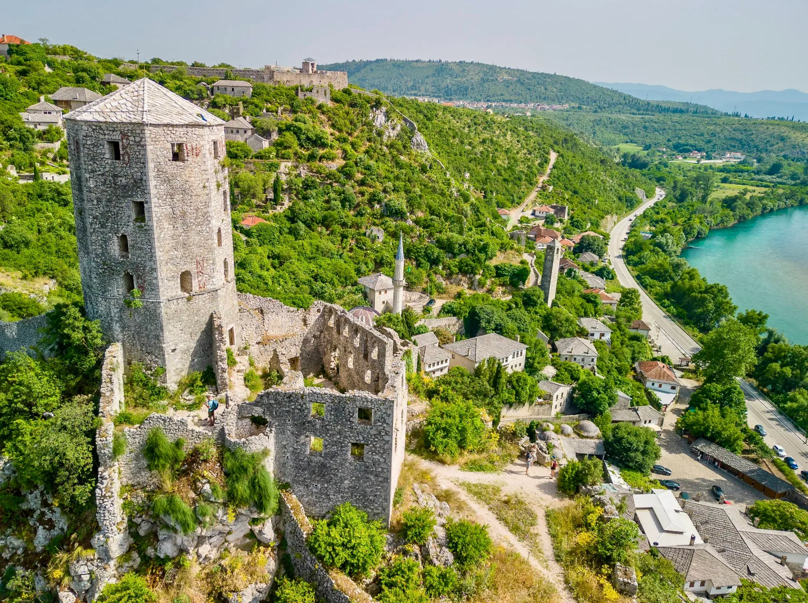 Ptičja perspektiva Starog grada Počitelja, kamene kule i bedemi okruženi gustim zelenilom