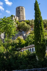 Pogled na kamenu kulu Starog grada Počitelja okruženu mediteranskim rastinjem
