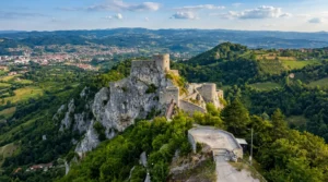 Istorijska tvrđava Stari grad Srebrenik snimljena iz vazduha na vrhu stene okružena zelenilom i brdima