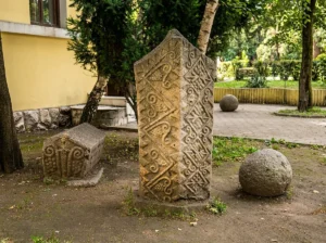 Uspravni kameni stećak sa prepoznatljivim ornamentima okružen drugim primjercima u parku u Zvorniku