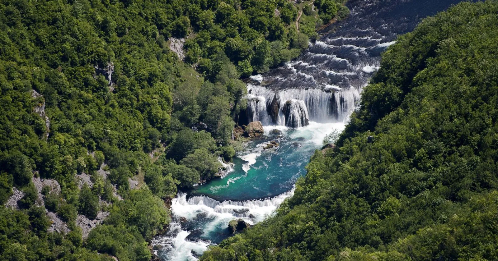 Panoramski pogled odozgo na Štrbački buk, višestruki slapovi rijeke Une okruženi gustom šumom