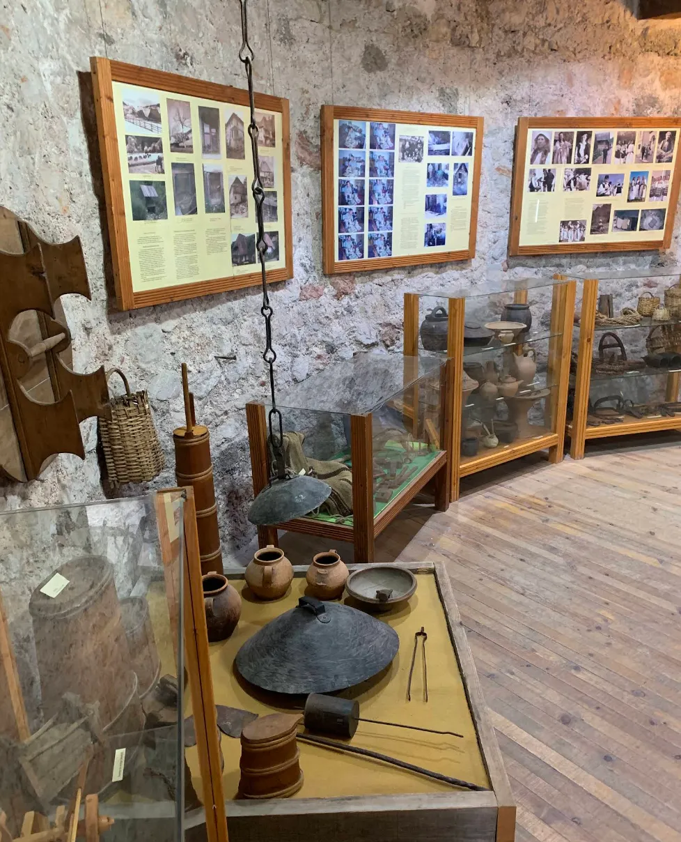 Muzejska postavka unutar Travničke tvrđave, historijski predmeti i fotografije na kamenim zidovima