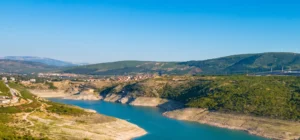 A beautiful view from Drakuljica Fortress of the clear lake water and the surrounding landscape