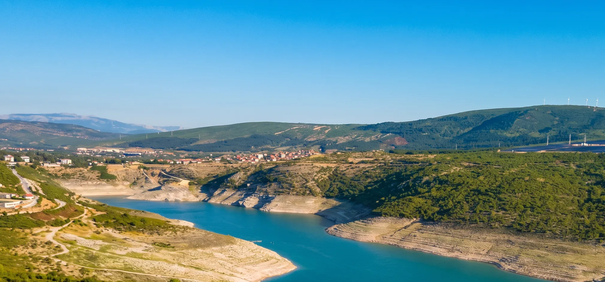 A beautiful view from Drakuljica Fortress of the clear lake water and the surrounding landscape