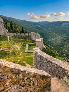 Herceg Stjepan Kosača kalesinin kalın taş surlarının üzerinden iç avluya ve Blagaj çevresindeki yeşil vadi ile dağ yamaçlarının etkileyici panoramasına bakış