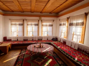Traditionally decorated interior of Eminagića konak with low tables and Bosnian rugs