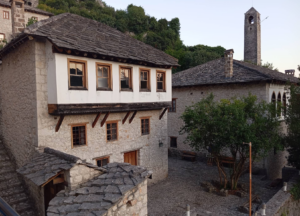  Dvorište Kuće Gavrankapetanovića u Počitelju, bijela fasada sa drvenim detaljima i kamenim popodom