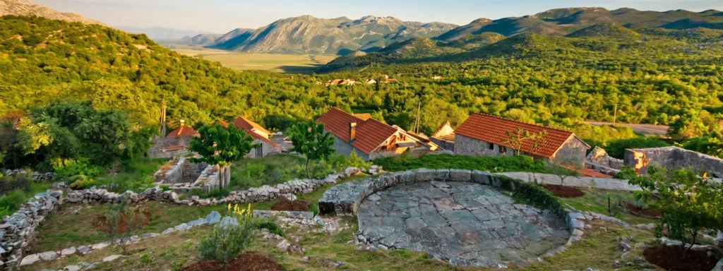 Selo Ravno Panoramski pogled na selo Ravno u Hercegovini, kamene kuće na krškom terenu okružene mediteranskom vegetacijom i planinama u pozadini