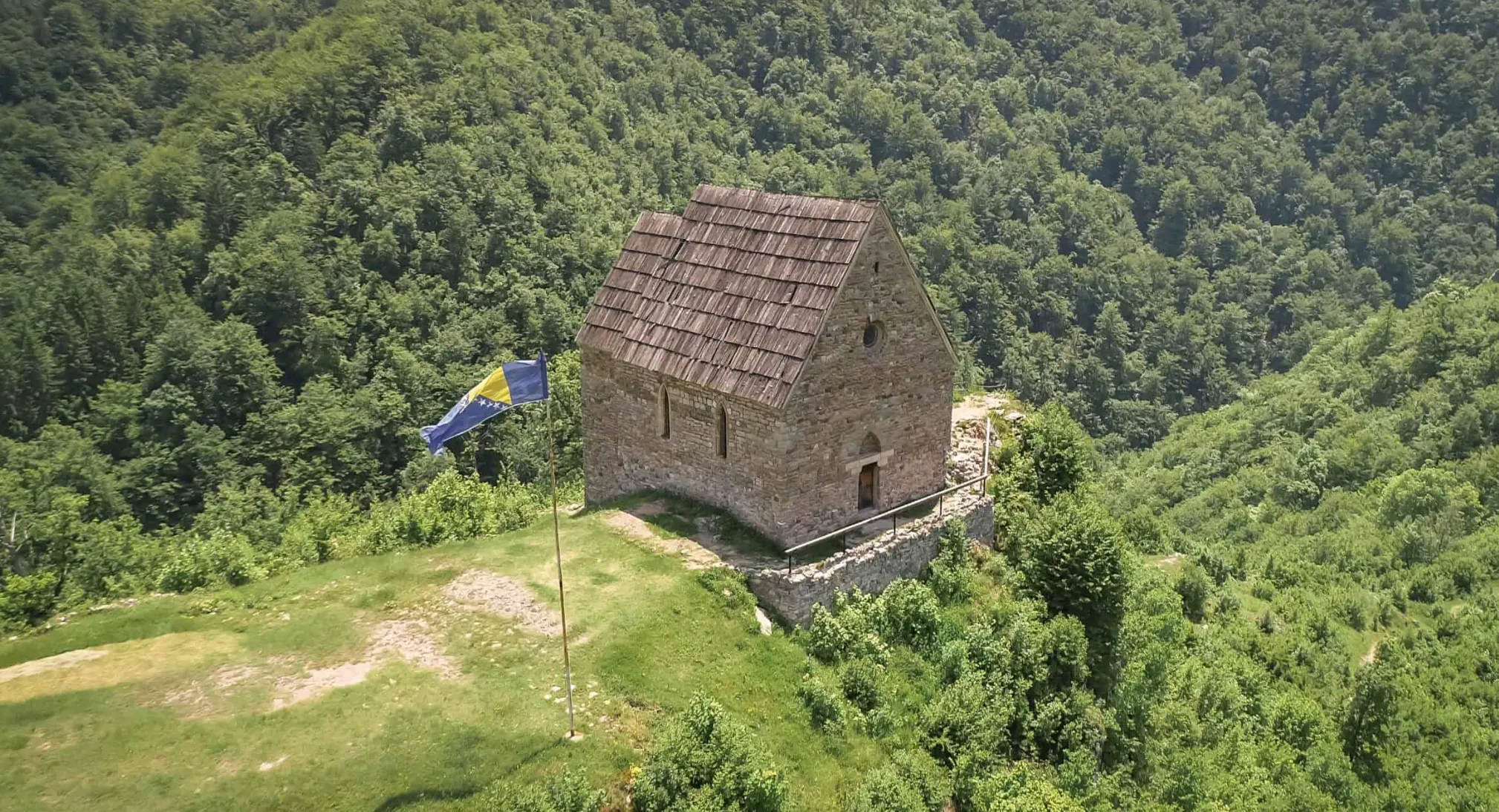  Ptičja perspektiva rekonstruirane kapele unutar Tvrđave Bobovac okružene gustom šumom