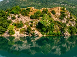 Natürliche Umgebung und Spiegelung der Felsen im Wasser des Flusses Trebišnjica am Fuße der Festung Mičevac