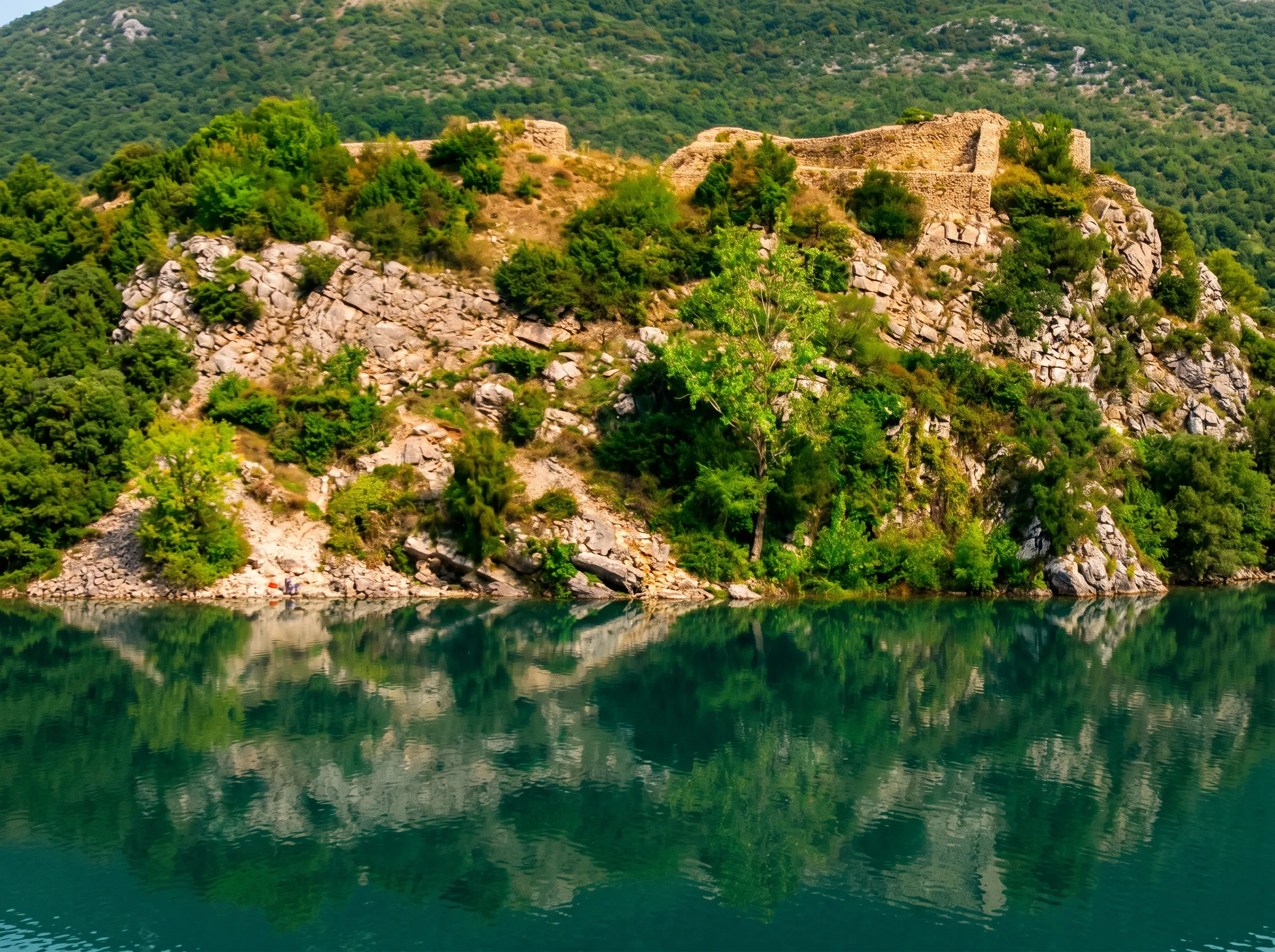 Natürliche Umgebung und Spiegelung der Felsen im Wasser des Flusses Trebišnjica am Fuße der Festung Mičevac